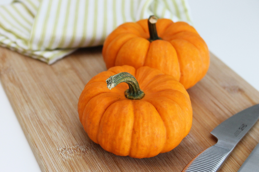 Small pumpkins on a wooden cutting board