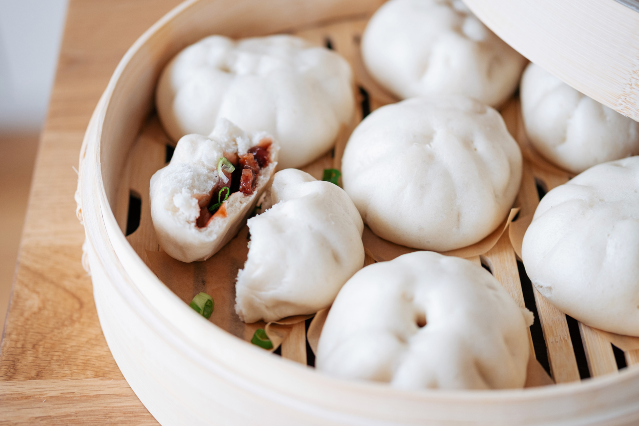 Fluffy BBQ Pork Bao Buns in a wooden steamer