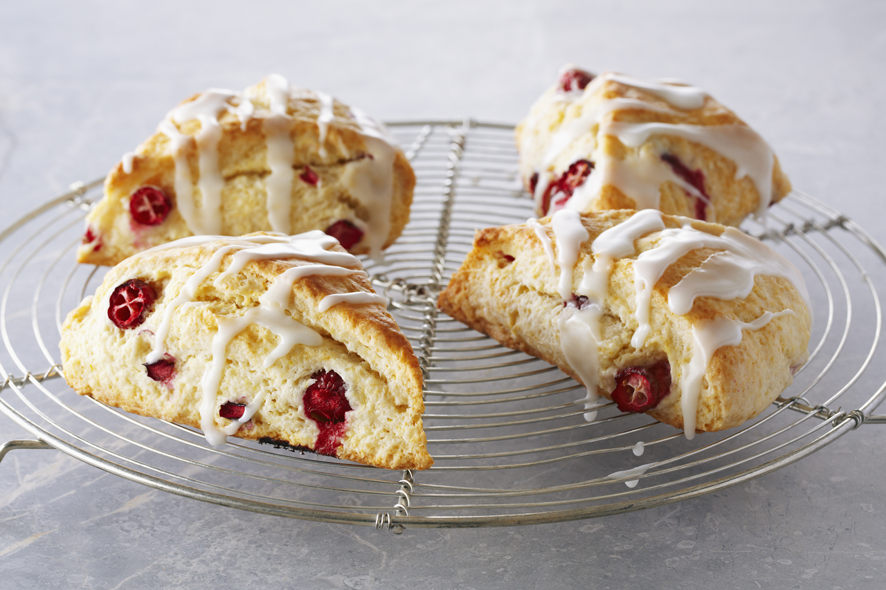 Classic lemon cranberry scones with lemon glaze on a rack