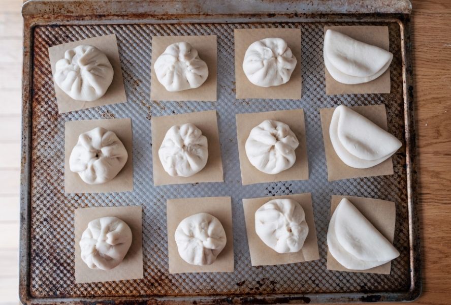 Uncooked bao buns on baking tray