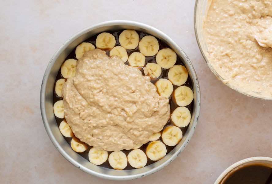 Banana upside down cake with toffee on bottom, sliced bananas and cake mix poured on top