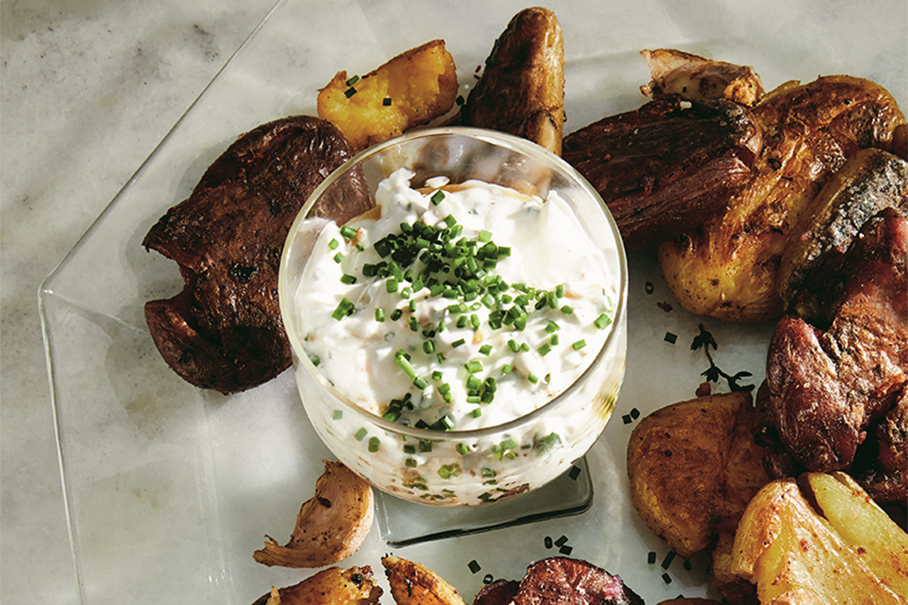 Overtop view of potatoes on a plate with a dip cup in the middle