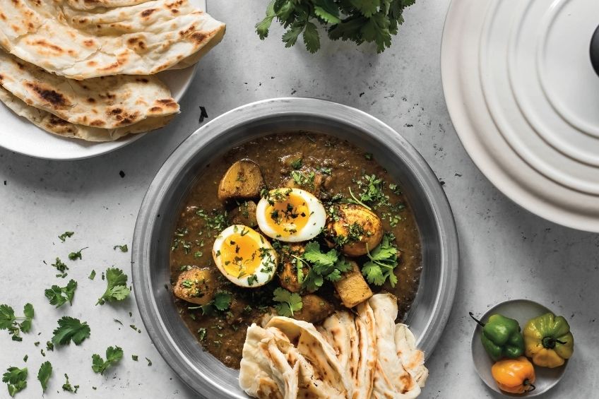 Egg curry and roti on kitchen countertop