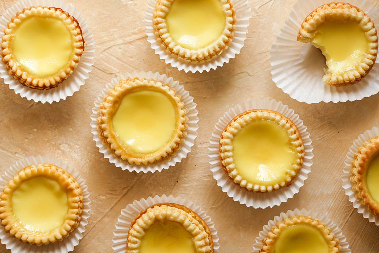 chinese egg tarts on a pale pink countertop