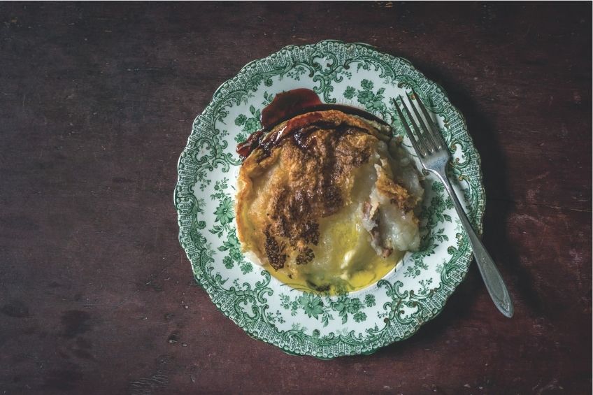 Acadian rappie pie on green and white plate