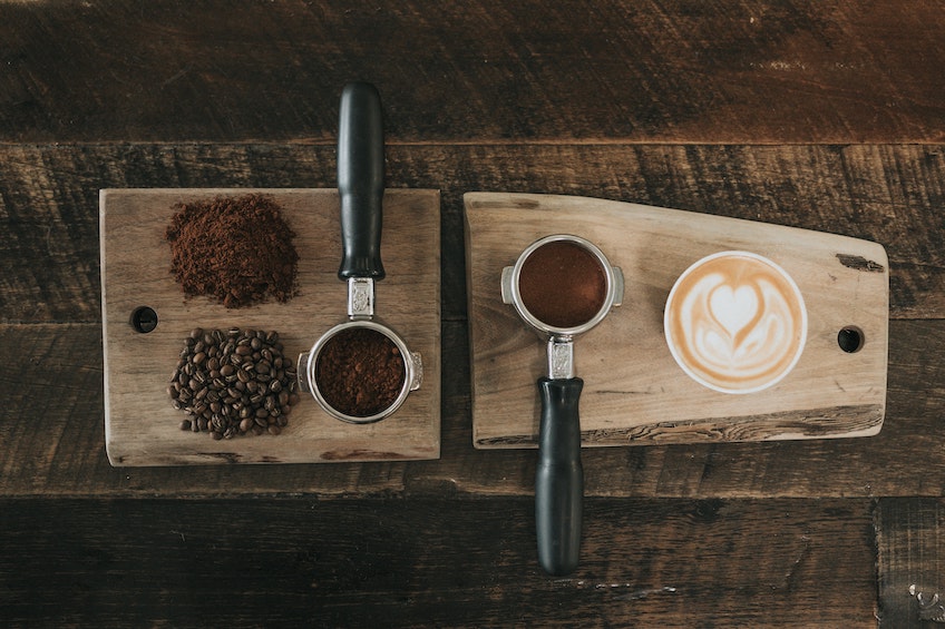 trays with coffee beans, ground coffee and latte