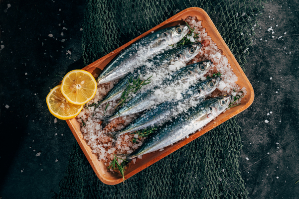 Salted fish on a tray against a black background