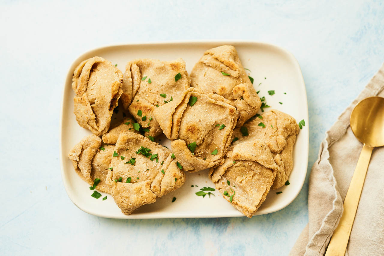 Jewish kreplach dumplings on a white plate