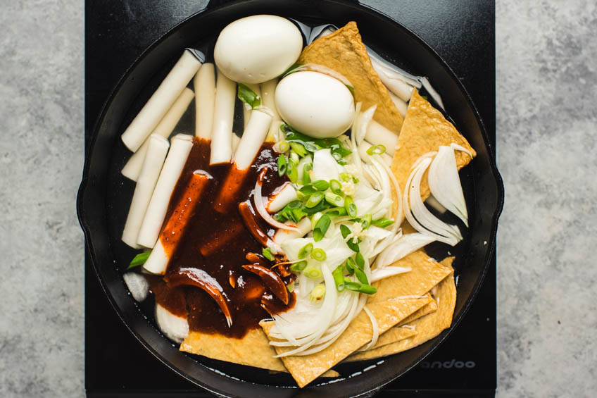 Ingredients for cheesy tteokbokki in a skillet