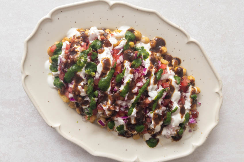 Chana chaat topped with mint chutney, tamarind sauce and yogurt