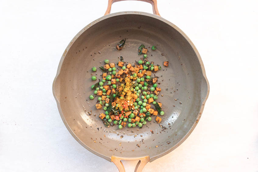 Ground spices, peas and carrots in a pan