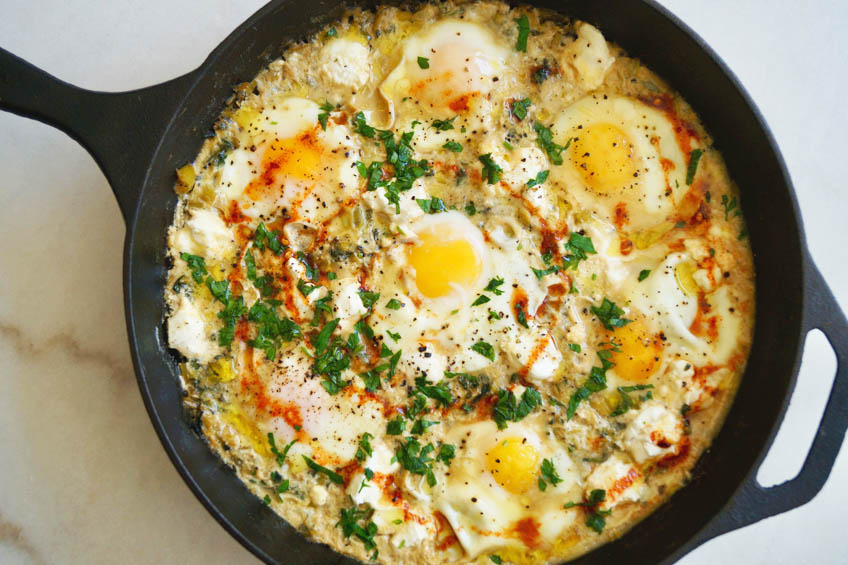 A closeup of creamy leek and spinach shakshuka