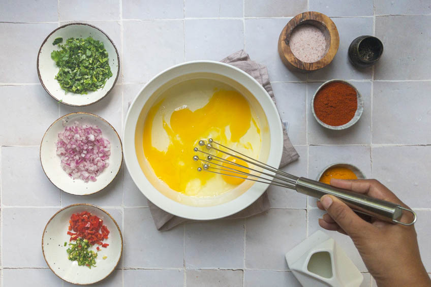 Eggs being whisked with milk in a bowl