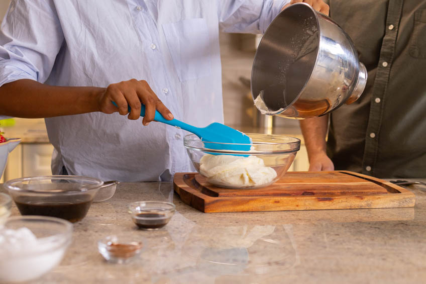 Whipped cream being transferred to a clean bowl