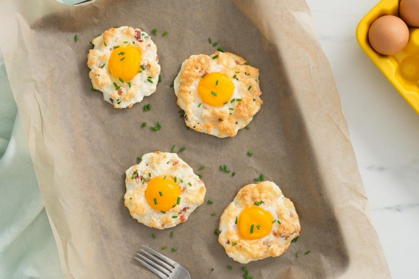 Cloud-like egg whites with a runny yolk in the centre on a baking sheet