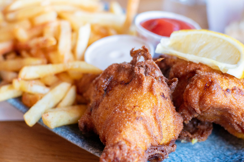 Fish and chips meal with lemon, tartar sauce and ketchup