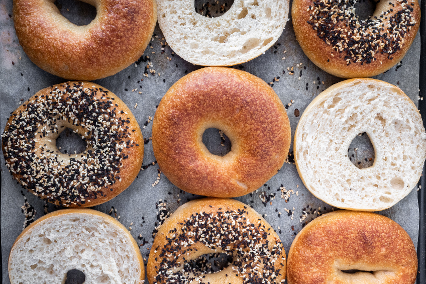 Overhead shot of various bagels cut in half, regular and sesame