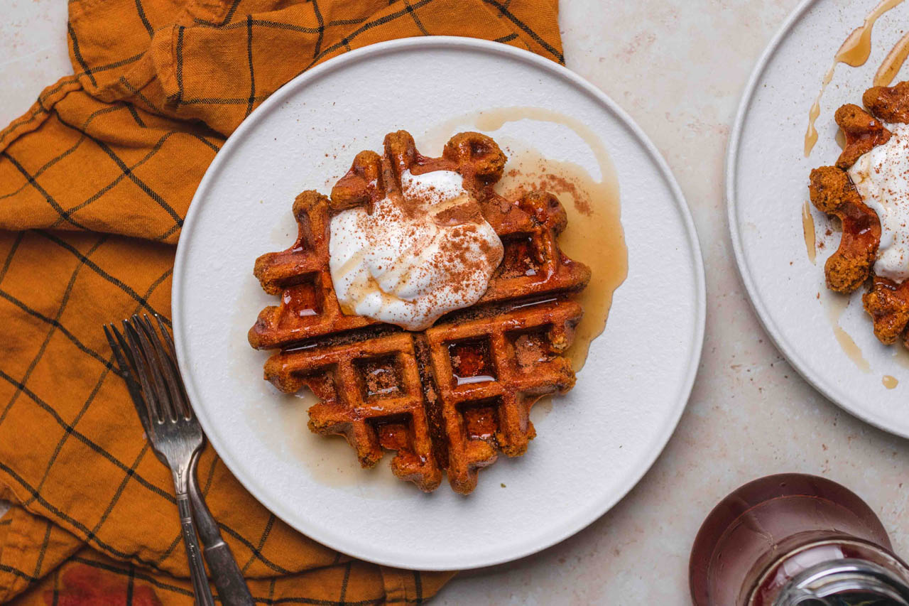 Vegan pumpkin waffles topped with vegan whipped cream