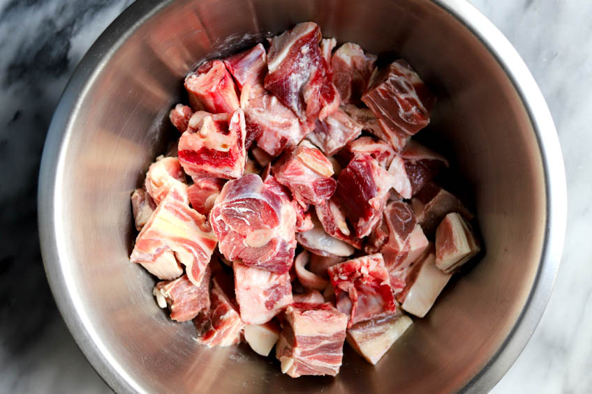 Cubed goat in a stainless steel bowl