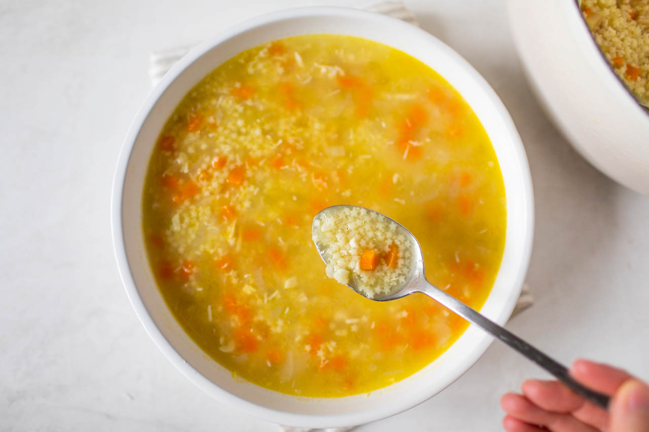 Italian Pastina Soup being scooped up with a spoon