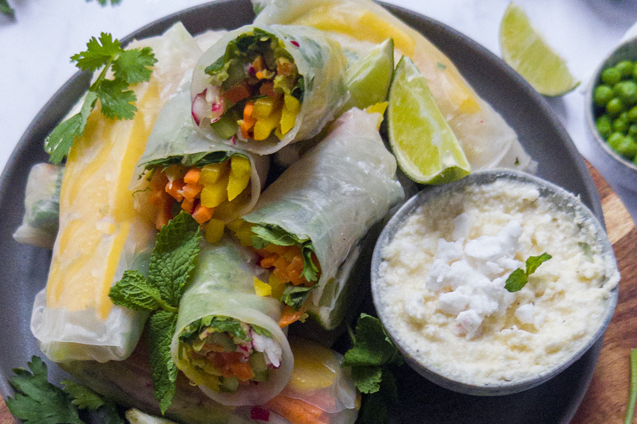 Summer rolls filled with strips of cucumber, mango, carrot and radish with a whipped feta dipping sauce