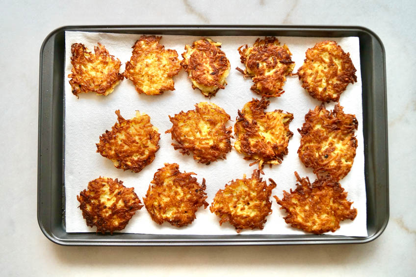 Latkes on a paper towel-lined baking sheet