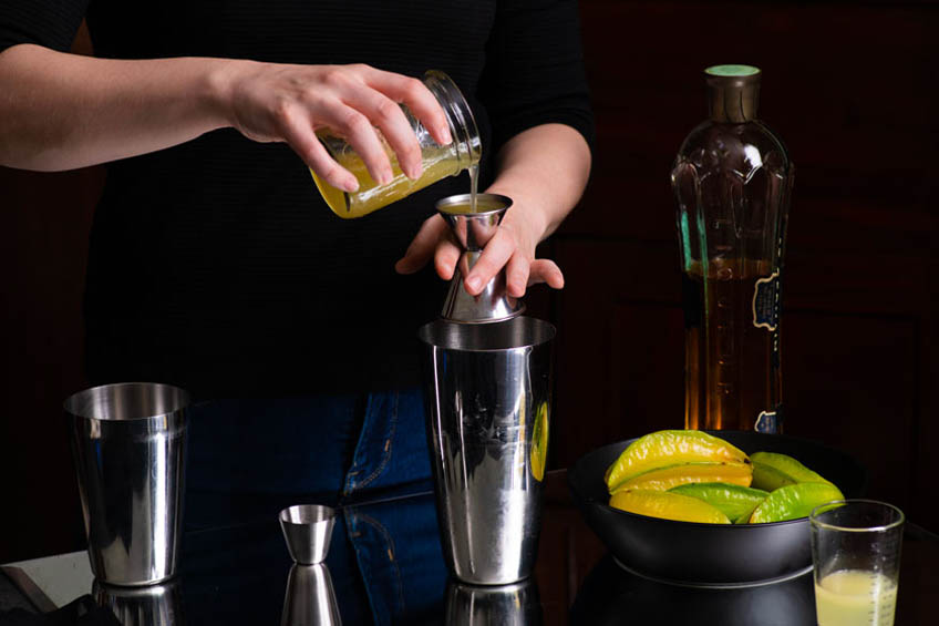 Ingredients being poured into a cocktail shaker for starlight sparkler cocktail