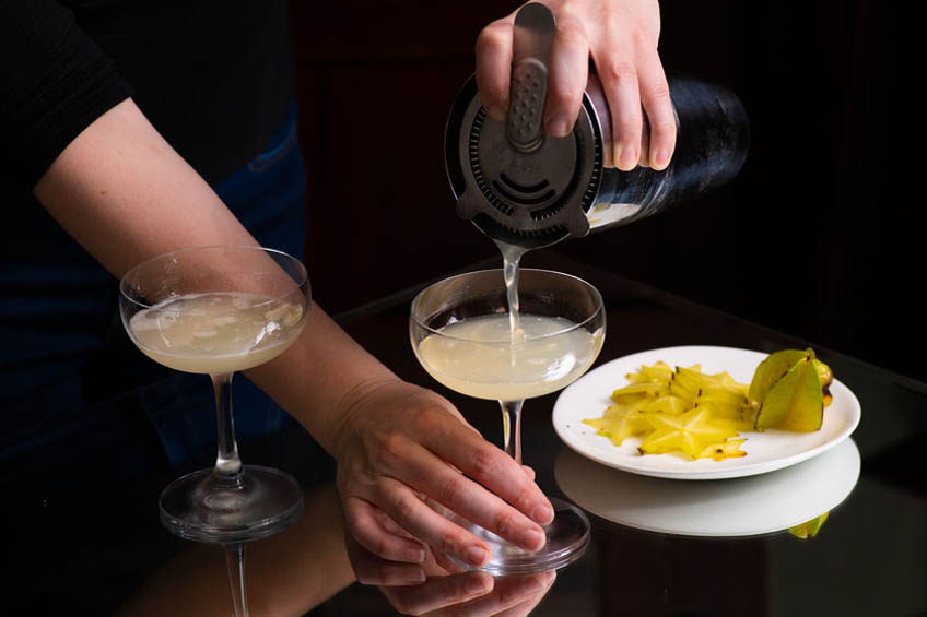 Starlight sparkler being strained and poured into a cocktail coupe