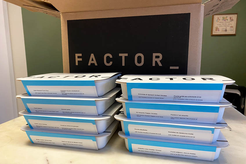 8 factor meals stacked in front of a Factor box