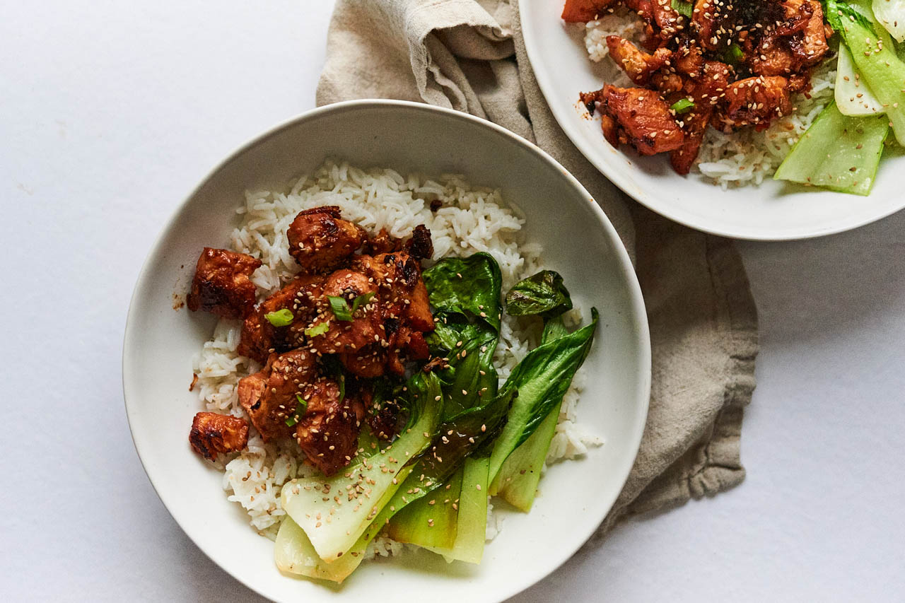 Honey ginger salmon pieces with bok choy over coconut rice in a bowl