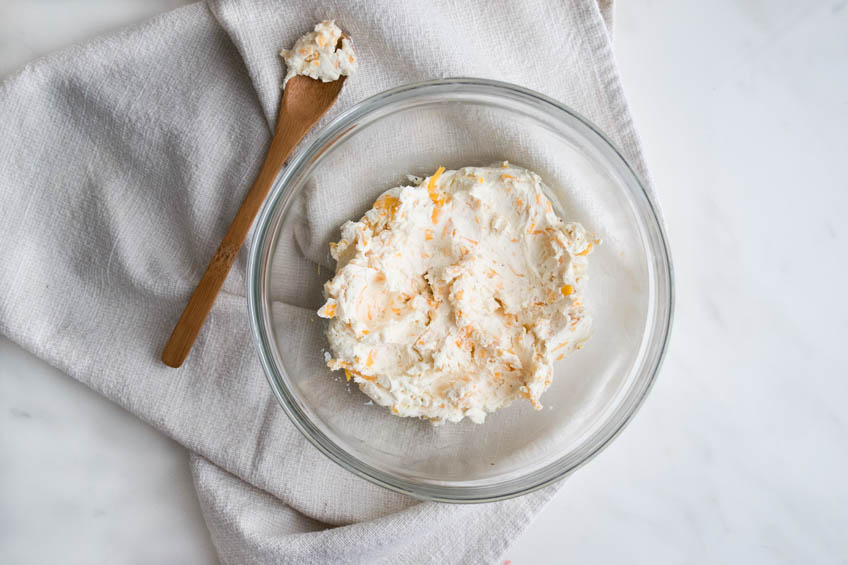 Cream cheese and cheddar filling for jalapeno poppers in a mixing bowl