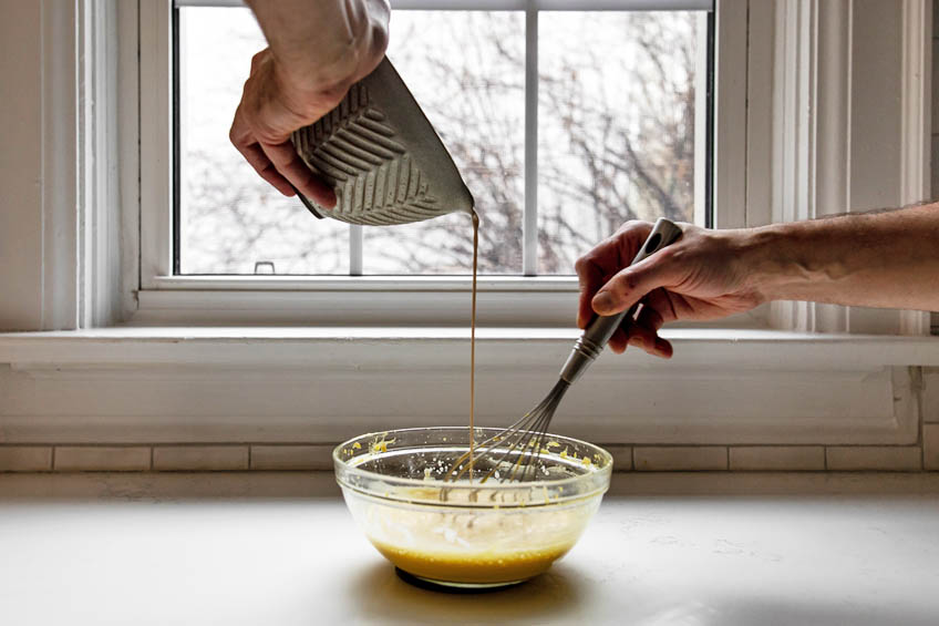 Chai being strained into egg and sugar mixture