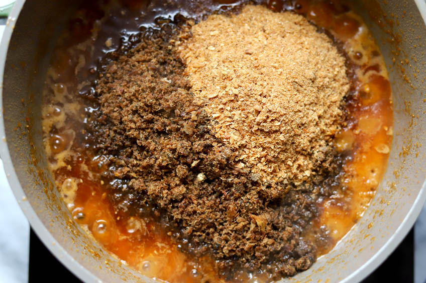 Dried fish powders being added to a pot of shito