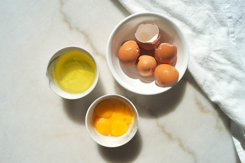 Egg whites and yolks divided into two bowls.