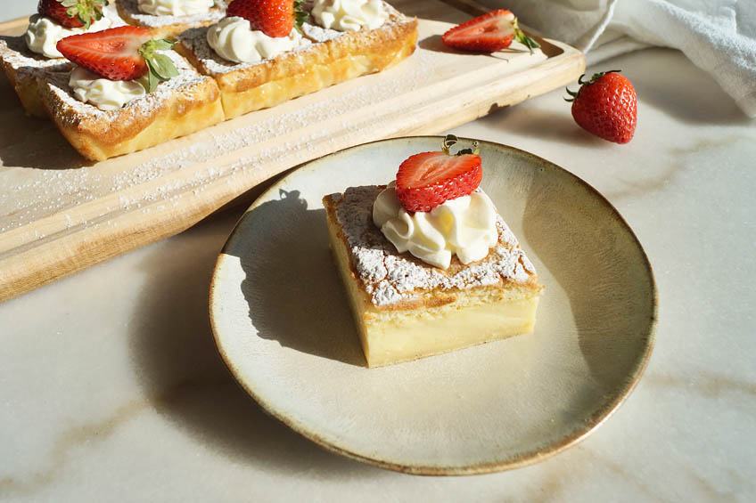 A slice of magic custard cake on a plate.