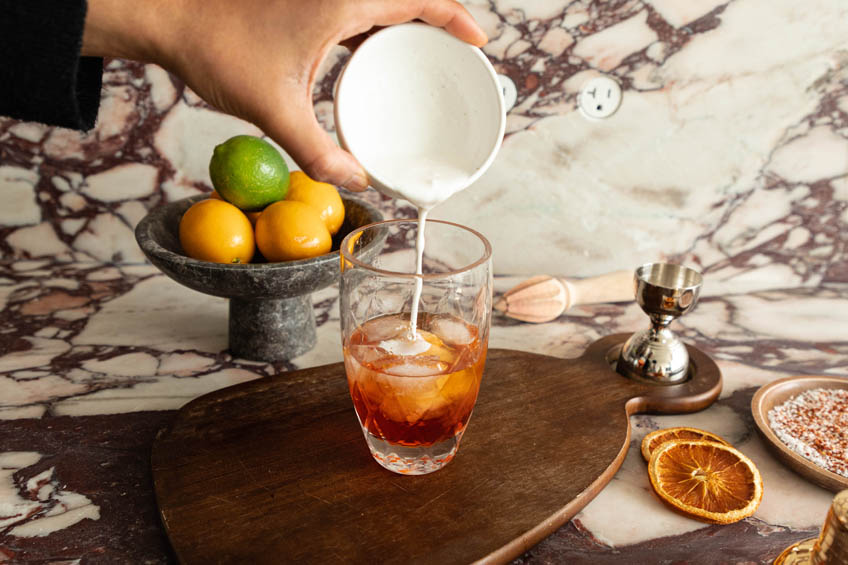 Ingredients being added to a glass for Aperol Margarita