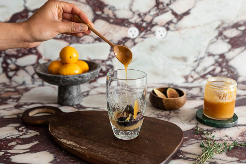 Honey being added to a cocktail shaker