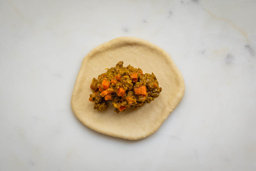 Flat dough topped with filling for Japanese curry bread