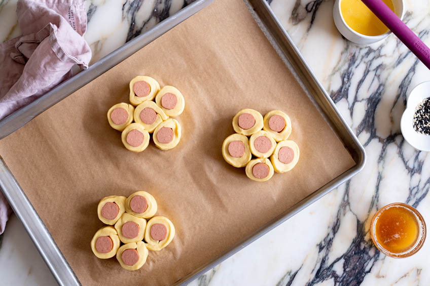 Unbaked Chinese Hotdog Flower Buns on a baking sheet