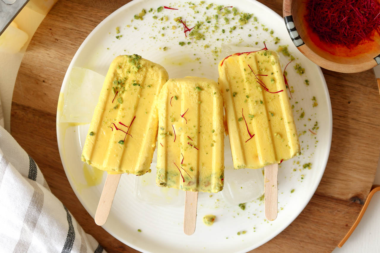 Saffron pistachio kulfi popsicleson a plate