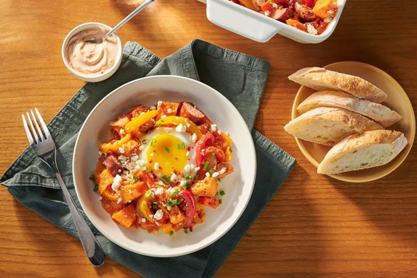 An egg casserole on a plate served with fresh French bread