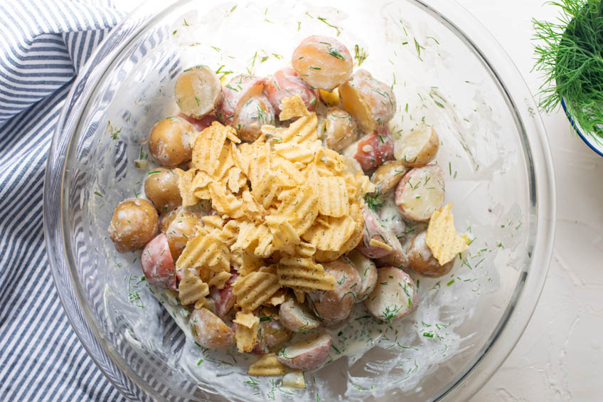 Creamy dill pickle potato salad topped with potato chips