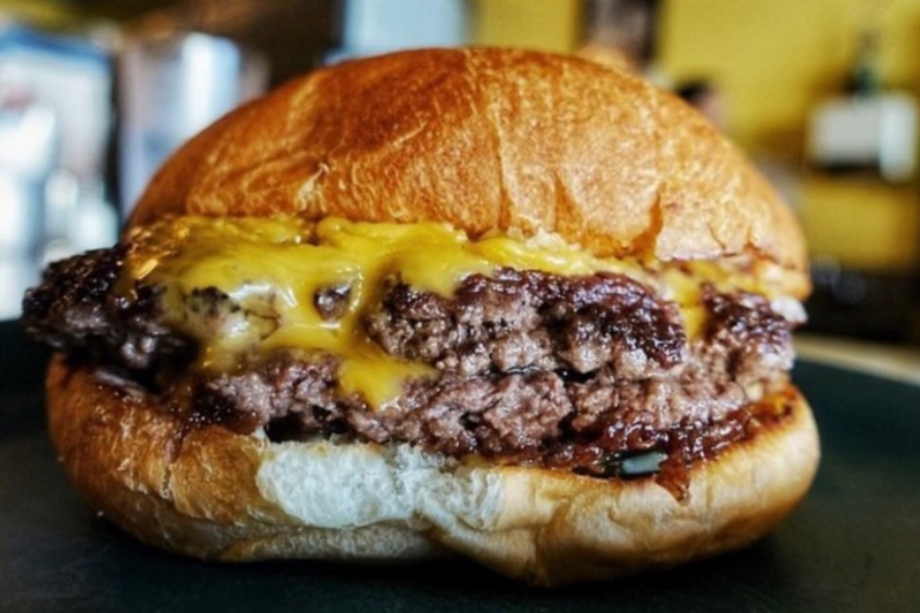 A double cheeseburger on a potato roll