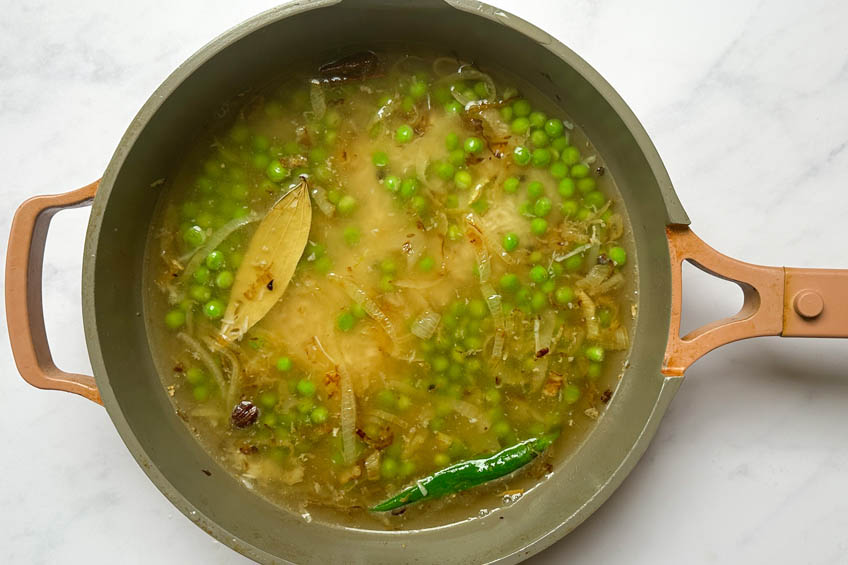 Matar pulao ingredients in a sauce pan