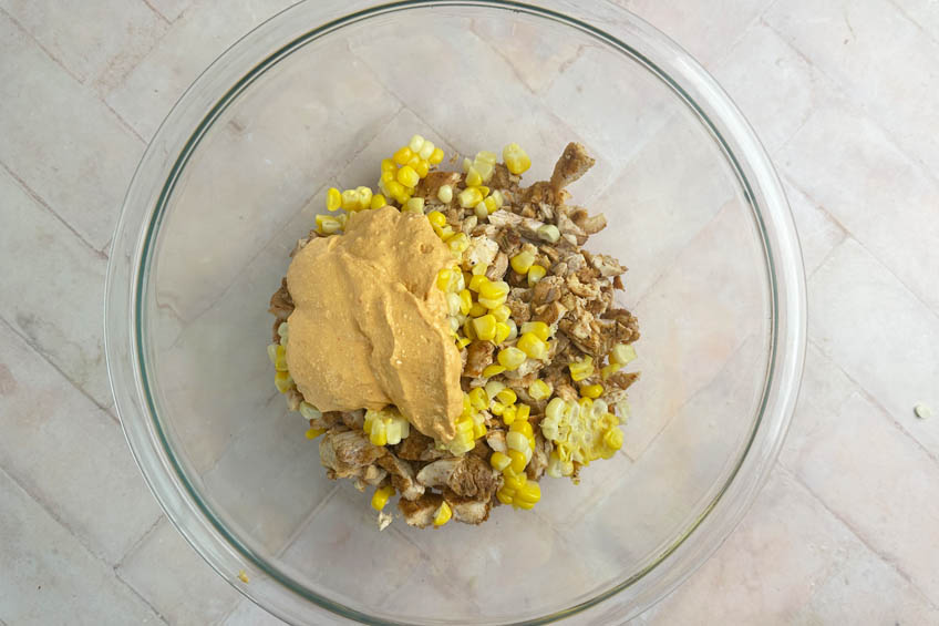 Grilled chicken, corn and cottage cheese sauce in a mixing bowl