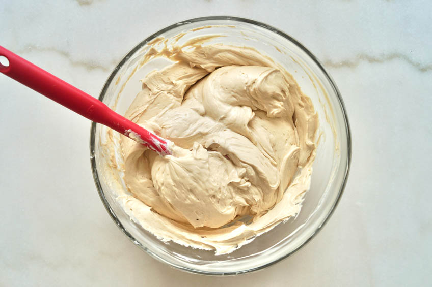 Cheesecake filling ingredients in a bowl with whipped cream added