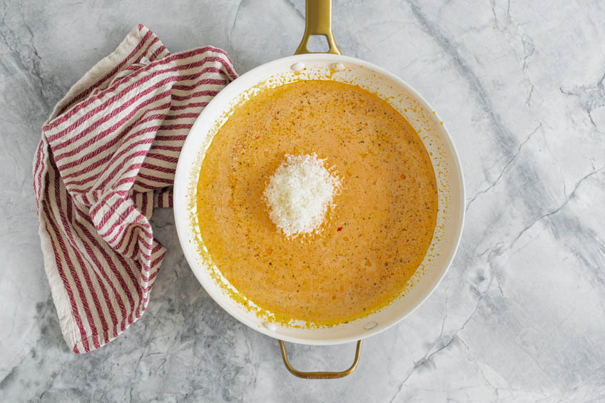 Cream and Parmesan cheese added to pan