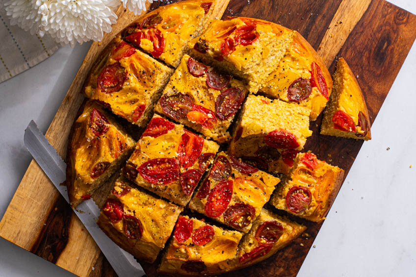 Cherry tomato cornbread, sliced on a serving board