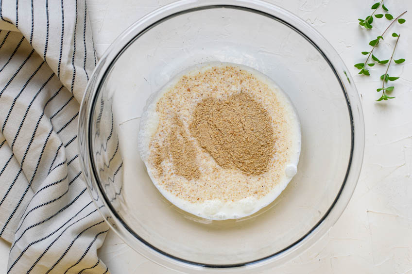 Milk and breadcrumbs in a mixing bowl