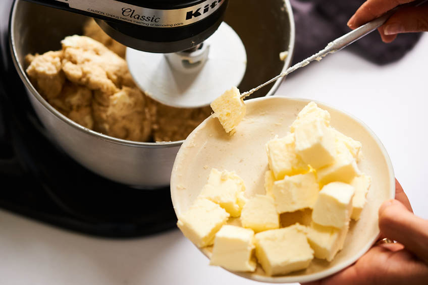 Butter being added to dough mixture